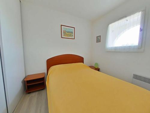 une chambre avec un lit jaune et une fenêtre dans l'établissement Maison à Bretignolles-sur-Mer : 2 ch, 4 pers, piscine sécurisée - FR-1-224A-39, à Bretignolles-sur-Mer