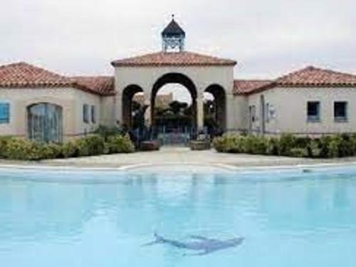 une grande piscine devant un immeuble dans l'établissement Maison à Bretignolles-sur-Mer : 2 ch, 4 pers, piscine sécurisée - FR-1-224A-39, à Bretignolles-sur-Mer