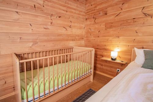 a crib in a room with a wooden wall at Weingut und Ferienhof Josef Huber in Oberkirch