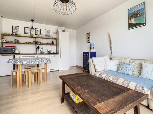 un salon avec un canapé et une table dans l'établissement Appartement 2 chambres proche mer - 1er étage, parking, cuisine équipée, TV et calme assuré - FR-1-236-77, à Stella-Plage