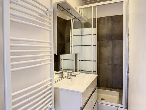 une salle de bain avec un lavabo et un miroir dans l'établissement Appartement 2 chambres proche mer - 1er étage, parking, cuisine équipée, TV et calme assuré - FR-1-236-77, à Stella-Plage