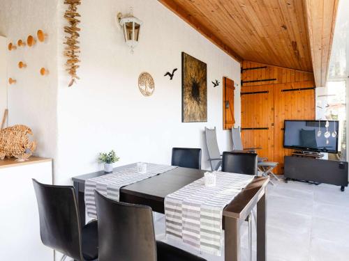 une salle à manger avec une table et des chaises et une télévision dans l'établissement Pavillon 2 pièces mezzanine, 5 pers, WIFI, animaux admis - FR-1-409-40, à Gruissan
