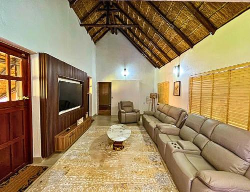 Una sala de estar con un sofá y un televisor. en Wood Valley, en Midrand