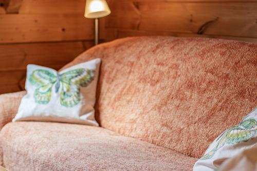 a pink couch with a bow pillow on it at Weingut und Ferienhof Josef Huber in Oberkirch