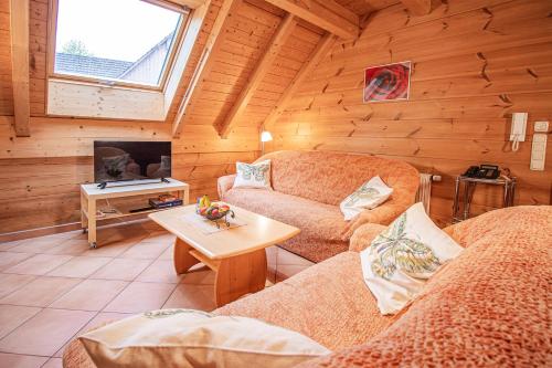 a living room with two couches and a tv at Weingut und Ferienhof Josef Huber in Oberkirch