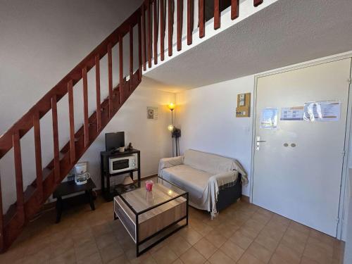 un salon avec un canapé et un escalier dans l'établissement Appartement 2 pièces avec mezzanine, piscine et parking à Narbonne Plage - FR-1-229B-63, à Narbonne