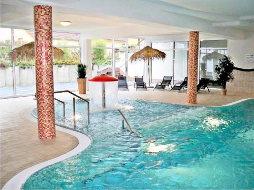 a large swimming pool in a hotel with columns at Strandläufer 111 in Granzow