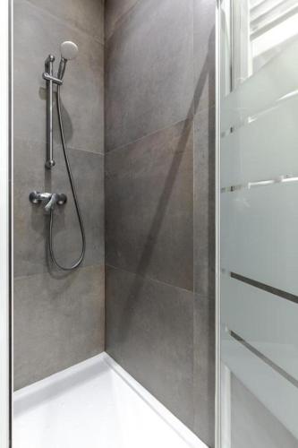 une douche avec une porte vitrée dans une salle de bain dans l'établissement Divry - Montparnasse Superbe Appartement 4P, à Paris