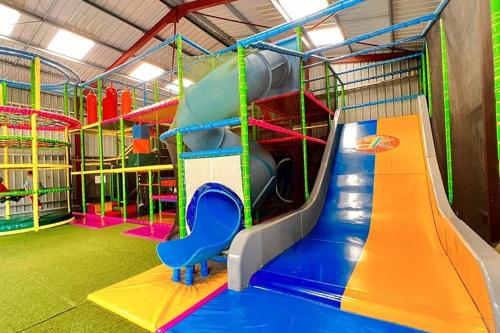 une salle de jeux avec un toboggan et un toboggan dans l'établissement Camping maeva Escapades Country Park - Touquin, à Touquin