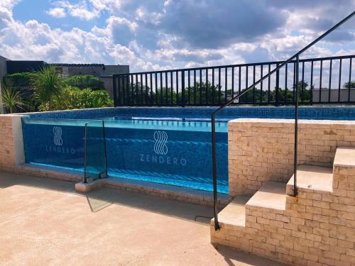 a swimming pool with a metal fence around it at Hotel Zendero Tulum in Tulum