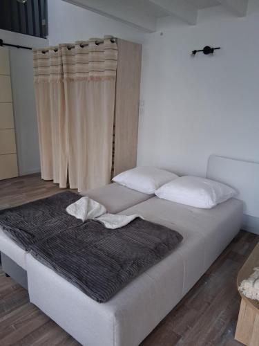 - un lit blanc avec une couverture noire dans l'établissement Grand Studio Mezzanine au calme dans l'hypercentre, à Rochefort