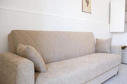 a couch sitting in a living room next to a wall at Elisena in Torre Lapillo