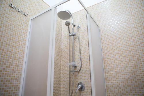 a shower with a glass door in a bathroom at Elisena in Torre Lapillo