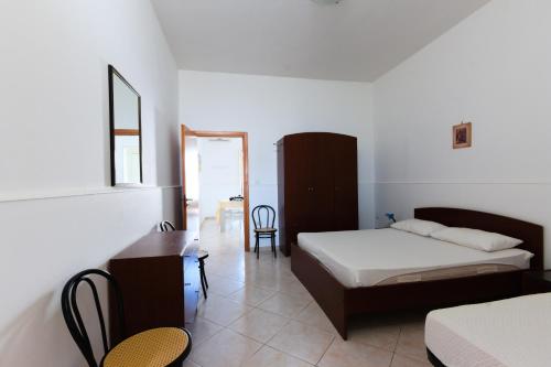 a bedroom with two beds and a desk in it at Elisena in Torre Lapillo