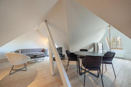 a living room with a table and chairs and a couch at Het Generaaltje in Hasselt