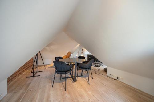 a dining room with a table and chairs in a attic at Het Generaaltje in Hasselt