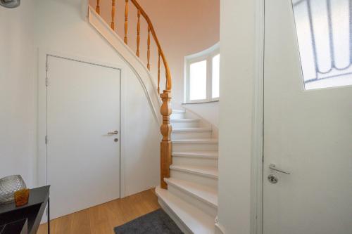 a staircase in a home with a white stair case at Het Generaaltje in Hasselt