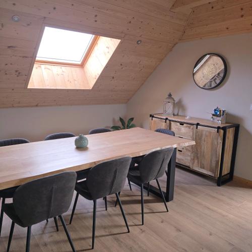 une chambre avec une table, des chaises et une lucarne dans l'établissement GITE Le grenier du Jean 8 personnes, à Sancey-le-Long