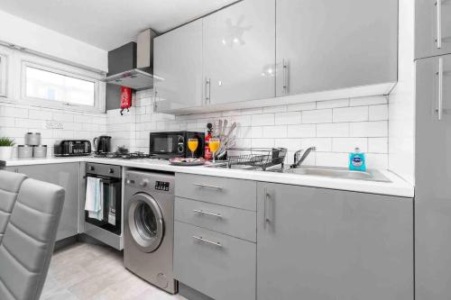 a kitchen with a sink and a washing machine at 2 Bedroom Apartment in Birmingham City-centre with Free Parking in Birmingham