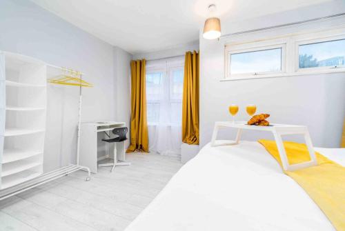 a white bedroom with a white bed and yellow curtains at 2 Bedroom Apartment in Birmingham City-centre with Free Parking in Birmingham