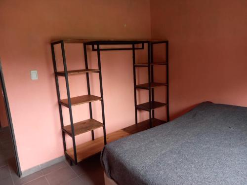 a room with a book shelf next to a bed at Cabaña al pie de las Sierras in Santa María