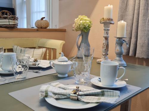 a table with plates and candles on top of it at Ferienwohnung Rose in Peißenberg