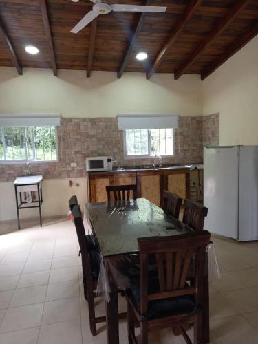 a kitchen with a table with chairs and a refrigerator at Cabaña al pie de las Sierras in Santa María
