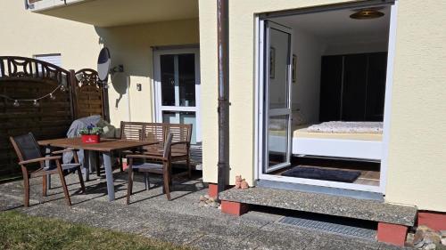 un patio con una mesa y una cama en una habitación en Ferienwohnung Schlossblick in Giengen Burgberg, en Giengen an der Brenz