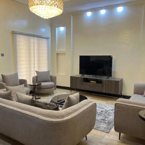 a living room with a couch and a flat screen tv at kaduna service apartment in Kaduna