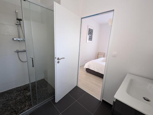 a bathroom with a glass door leading to a bedroom at Maison familiale avec jardin a deux pas de l'océan in Préfailles
