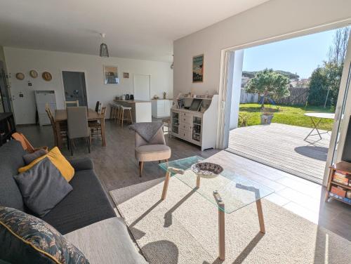 un salon avec un canapé et une table dans l'établissement Maison familiale avec jardin a deux pas de l'océan, à Préfailles