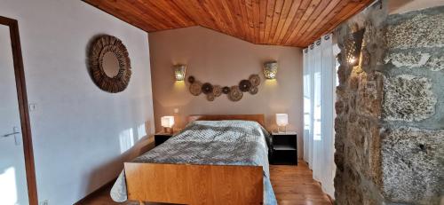 une chambre avec un lit et un mur en pierre dans l'établissement Maison en Ardèche, à Empurany