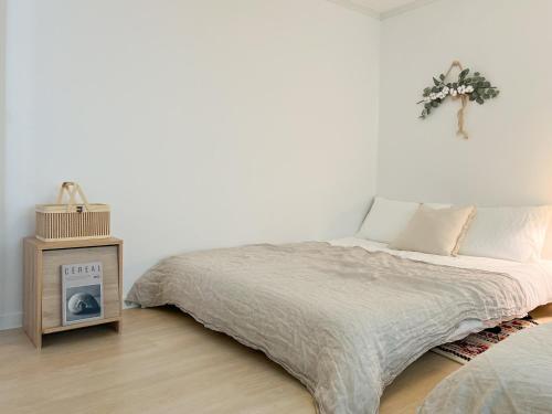 a bedroom with a bed and a table with a clock at JAJA Haenggung, SuwonㅣNext to Hwaseong FortressㅣCozy Korean VibeㅣComfortable & Well-keptㅣUp to 8 guestsㅣFree Parkingㅣ2-night minimumㅣLoved by many guests in Suwon