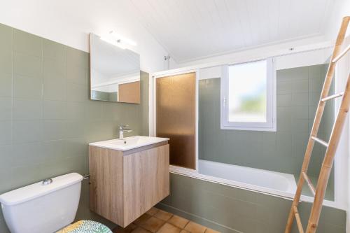 a bathroom with a sink and a toilet and a window at Le 5 Mimosas - Plage à 600m garage in Saint-Jean-de-Monts