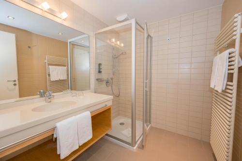 ein Badezimmer mit Waschbecken und Dusche in der Unterkunft Allegria Resort Stegersbach - Allegria Hotel in Stegersbach