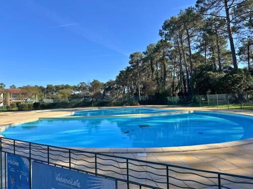 a large swimming pool with a fence around it at L'Eclat Terrasse - Piscine - Tennis in Ondres
