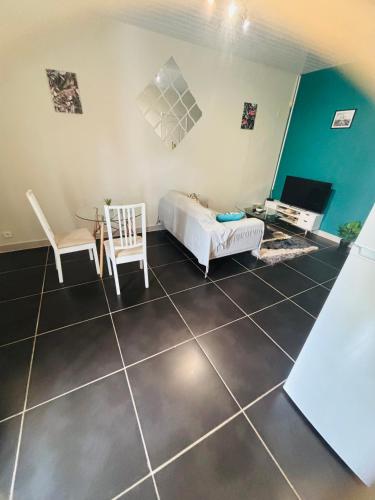 a room with a bed and a table and chairs at Sermie T2 climatisé avec piscine in Kourou
