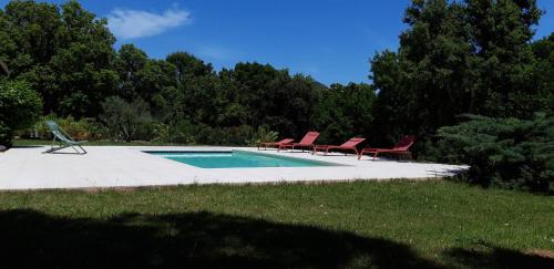 - une piscine avec 2 chaises et une piscine dans l'établissement romantique, à Sainte-Lucie de Porto-Vecchio