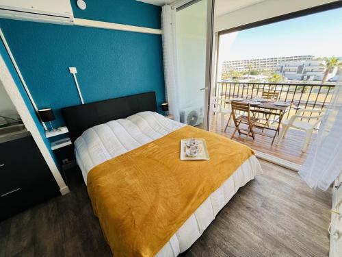une chambre avec un lit et un balcon avec une table dans l'établissement Studio naturiste bord de mer, terrasse sud, clim, parking - FR-1-249A-44, au Cap d'Agde