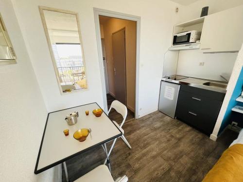 Ce petit appartement comprend une table et une cuisine. dans l'établissement Studio naturiste bord de mer, terrasse sud, clim, parking - FR-1-249A-44, au Cap d'Agde