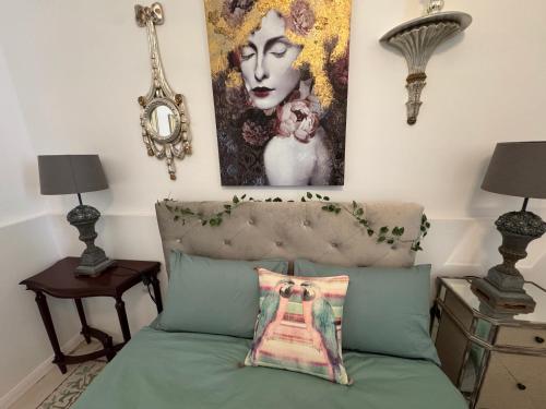 una camera da letto con un letto e un dipinto sul muro di Central Boutique Apartment Near Valletta with Cafeteria Just Next Door - Perfect for Couples Wanting to Discover Malta - Bus Stops Just Outside a Msida