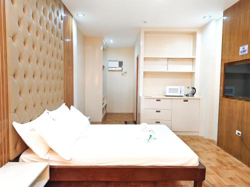 a bedroom with a large bed and a microwave at Dreaming Forest Hotel - Libjo, Batangas in Batangas City