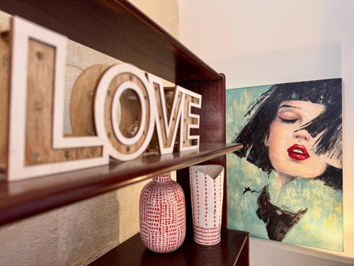 uno scaffale con due vasi e un cartello con la scritta uno di Central Boutique Apartment Near Valletta with Cafeteria Just Next Door - Perfect for Couples Wanting to Discover Malta - Bus Stops Just Outside a Msida
