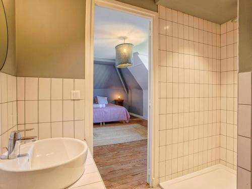 La salle de bains est pourvue d'un lavabo et d'un lit. dans l'établissement Maison familiale avec sauna et ferme proche plage - FR-1-788-49, à Gonneville-en-Auge