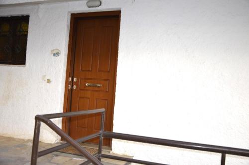 a brown door in a white building at COZY Apt BY THE SEA AT VOULIAGMENI in Athens