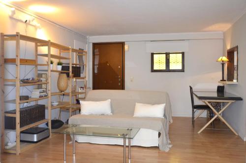 a bedroom with a bed and a table and a desk at COZY Apt BY THE SEA AT VOULIAGMENI in Athens