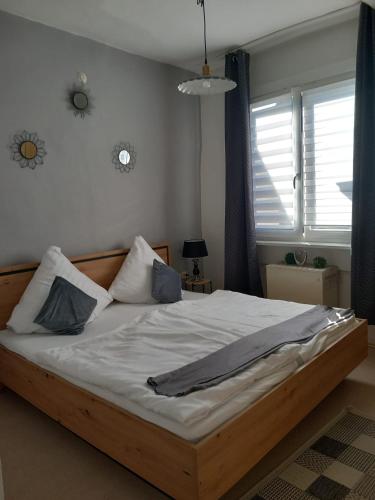 a bed with white sheets and blue pillows in a bedroom at Altstadt Oase Bernkastel-kues in Bernkastel-Kues