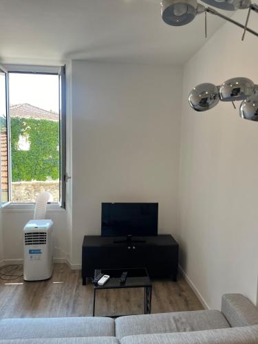 un salon avec un canapé, une table et une fenêtre dans l'établissement Charming studio in a good location, à Vallauris