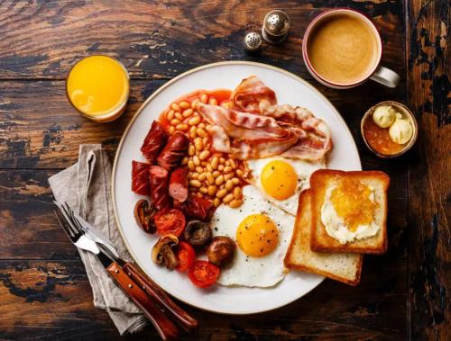 a plate of breakfast food with eggs beans and toast at LA Riqueza Koala Inn Mcleo Ganj # Close to Mall Road # Rooftop Restaurant with Mountain View # In-house Parking in McLeod Ganj