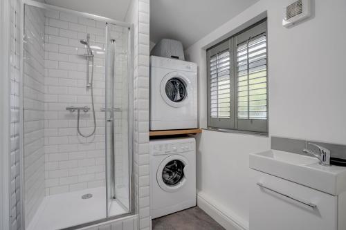 - une buanderie blanche avec lave-linge et sèche-linge dans l'établissement Amity House by Winterton Cottages, à Winterton-on-Sea